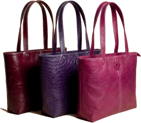 Three leather tote bags in burgundy, purple and magenta