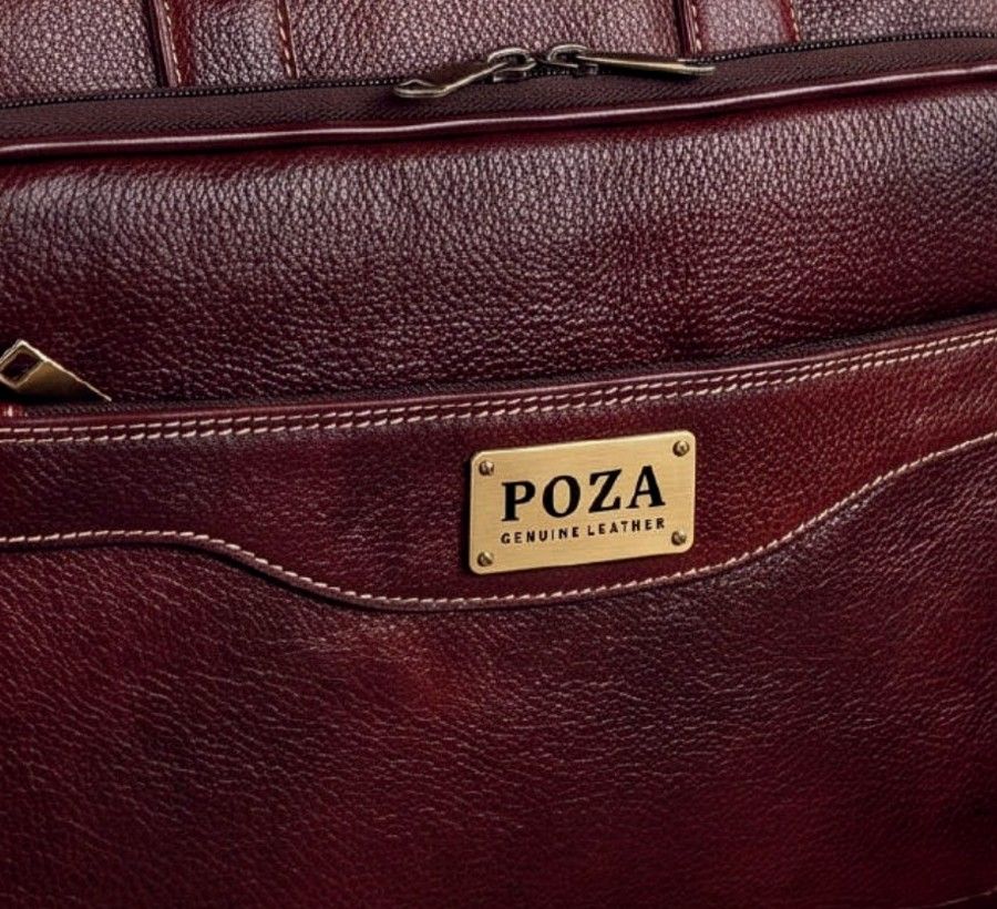 Brass POZA logo plate on a burgundy leather bag